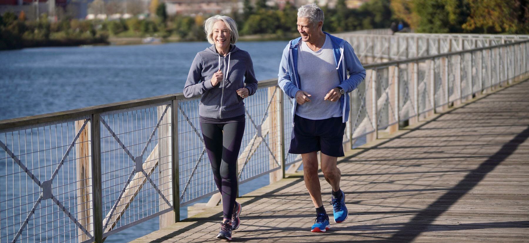 Altes Ehepaar joggt am Ufer, um sich fit zu halten und in Bewegung zu bleiben.